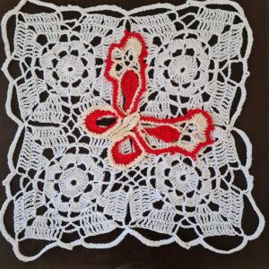 Crochet side table mat in white with a red butterfly motif by Triggerfish Crochet