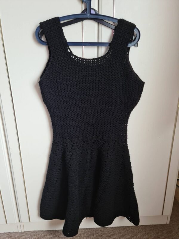 Black crochet dress on a hanger