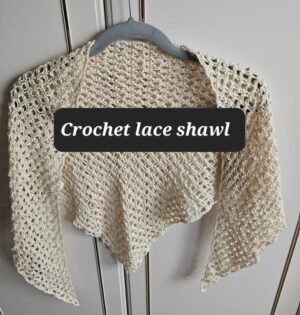 Crochet Lace Shawl in Cream colour on a hanger by Triggerfishcrochet